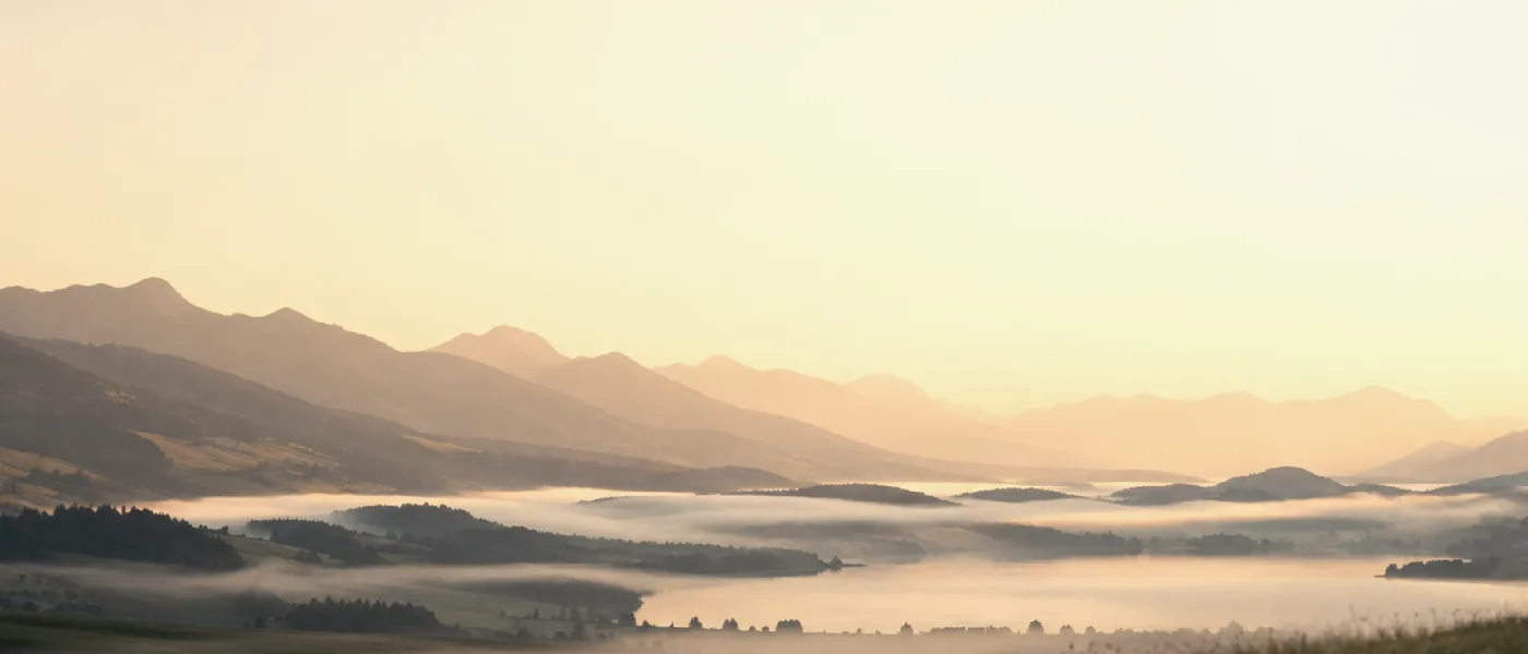 Berge und ein See im Morgennebel
